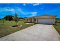 House exterior showcasing a two-car garage and a spacious front yard at 15190 Cr-565A, Clermont, FL 34711