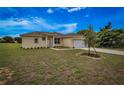 A tan house with a two-car garage and a neatly landscaped yard at 15190 Cr-565A, Clermont, FL 34711