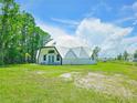 Modern dome house on a large grassy lot with mature trees at 624 Volco Rd, Edgewater, FL 32141