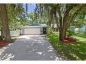 House exterior showcasing a driveway and mature trees at 1319 Orange Tree Dr, Edgewater, FL 32132
