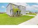 Two-story house with gray siding, two-car garage and manicured lawn at 3242 Carpentaria Dr, New Smyrna Beach, FL 32168