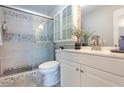 Clean bathroom with a white vanity, glass shower, and gray tile at 3750 S Atlantic Ave # 180, Daytona Beach Shores, FL 32118