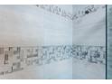 Shower with gray and white mosaic tile and glass door at 3750 S Atlantic Ave # 180, Daytona Beach Shores, FL 32118