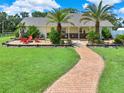 Single story house with a brick pathway, palm trees, and a relaxing patio at 3650 Pepper Ln, New Smyrna Beach, FL 32168