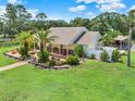 Single story house with a large yard, palm trees and a patio at 3650 Pepper Ln, New Smyrna Beach, FL 32168