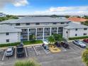 Exterior view of condo building with parking and landscaping at 2100 N Peninsula Ave # 1150, New Smyrna Beach, FL 32169
