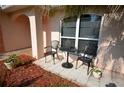Small patio with wrought iron furniture and landscaping at 2624 Turnbull Estates Dr, New Smyrna Beach, FL 32168