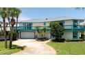 Two-story house with teal accents and a large yard at 320 Due East St, New Smyrna Beach, FL 32169