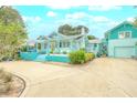 Quaint teal home with a spacious driveway and landscaping at 412 S Peninsula Ave, New Smyrna Beach, FL 32169