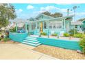 Bright teal house with a porch, steps, and a pergola at 412 S Peninsula Ave, New Smyrna Beach, FL 32169