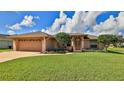 Single-story home with two car garage and well manicured lawn at 215 Golf Club Dr, New Smyrna Beach, FL 32168