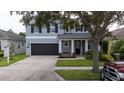 Two-story house with gray exterior, black shutters, and a two car garage at 2706 Atlantis Dr, New Smyrna Beach, FL 32168