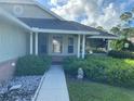 House exterior showcasing a walkway, landscaping, and screened porch at 101 Braeburn Cir, Daytona Beach, FL 32114