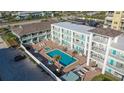 Aerial view of a beachside community featuring a pool, patio furniture, and multiple buildings at 3509 S Atlantic Ave # 209, New Smyrna Beach, FL 32169