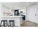 Modern kitchen with white and teal cabinets, quartz countertops, and stainless steel appliances at 241 Riverside Dr # 2007, Holly Hill, FL 32117