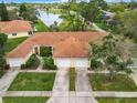 An aerial shot showcasing a charming villa-style home with a double garage at 1805 Turnbull Lakes Dr, New Smyrna Beach, FL 32168