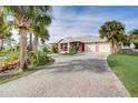 Coral house with metal roof, double garage, and lush landscaping at 300 Quay Assisi Ct, New Smyrna Beach, FL 32169