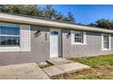 Front entry of a single-story house with white door and landscaping at 1004 W 7Th St, New Smyrna Beach, FL 32168