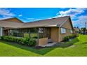 Tan house with screened porch and well-manicured lawn at 11 Andrea Dr, New Smyrna Beach, FL 32168