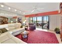 Living room with a white leather sectional sofa, a view, and a balcony at 731 Marina Point Dr # 7310, Daytona Beach, FL 32114