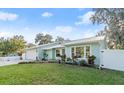 Newly painted light blue house with a metal roof and landscaped yard at 336 S Walker Dr, New Smyrna Beach, FL 32168