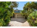 Two-story house with a large garage and tropical landscaping at 69 S Turn Cir, Ponce Inlet, FL 32127