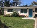 Charming Ranch style home with teal door and landscaped yard at 113 Neptune Dr, Edgewater, FL 32132