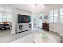 Bright living room with a large TV, light grey furniture, and hardwood floors at 456 Lime Ave, Daytona Beach, FL 32124