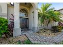 Front entryway with a dark brown door, arched entryway, and landscaped walkway at 510 Sun Lake Dr, Port Orange, FL 32127