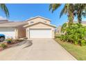 Tan townhome with white garage door and driveway at 2266 Hawks Cove Cir, New Smyrna Beach, FL 32168