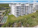 Oceanfront building with balconies, lawn, and shuffleboard at 5303 S Atlantic Ave # 270, New Smyrna Beach, FL 32169