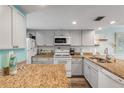 Well-equipped kitchen with granite countertops and white cabinets at 3801 S Atlantic Ave # 307, New Smyrna Beach, FL 32169
