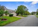 Wide shot of tan house with a two-car garage and lush landscaping at 172 Gull S Dr, Daytona Beach, FL 32119