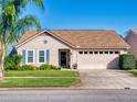 One-story home with light beige siding, brown roof, and a two-car garage at 803 Pine Shores Cir, New Smyrna Beach, FL 32168