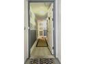 Bright entryway with gray and white striped wall, wood-look flooring, and a welcoming door at 5207 S Atlantic Ave # 0622, New Smyrna Beach, FL 32169
