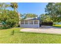 Gray house with a screened porch and a spacious yard at 1873 Pioneer Trl, New Smyrna Beach, FL 32168