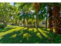 Bright yellow house nestled amongst palm trees and lush greenery at 132 Ellison Ave, New Smyrna Beach, FL 32168