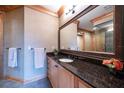 Bathroom featuring granite countertops, wood cabinets, and a large mirror at 1653 N Us Highway 1 # 201, Ormond Beach, FL 32174
