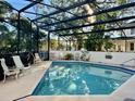 Community pool with screened enclosure and seating at 200 S Riverside Dr # 2010, New Smyrna Beach, FL 32168