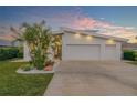 Modern home exterior showcasing a three-car garage and tropical landscaping at 2022 N Peninsula Ave, New Smyrna Beach, FL 32169