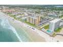 Aerial view of beachfront property with ocean, building, and parking at 3501 S Atlantic Ave # 407, New Smyrna Beach, FL 32169