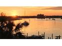 Stunning sunset over calm water with boats and palm trees at 460 Bouchelle Dr # 305, New Smyrna Beach, FL 32169
