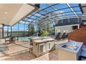 Outdoor kitchen and pool with a screened enclosure at 535 Valley Stream Dr, Geneva, FL 32732