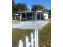 Front view of a white house with a carport and a yard at 2017 Royal Palm Dr, Edgewater, FL 32141