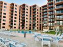 Relaxing pool and patio area with lounge chairs and tables at 4141 S Atlantic Ave # 605, New Smyrna Beach, FL 32169