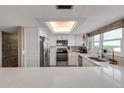 Bright white kitchen with stainless appliances and quartz countertops at 5499 S Atlantic Ave # 905, New Smyrna Beach, FL 32169