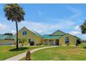 Stunning yellow house with green roof, and nicely landscaped yard at 886 Matthews Ave, New Smyrna Beach, FL 32169