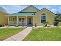 Inviting yellow house with a green roof and a spacious front porch at 886 Matthews Ave, New Smyrna Beach, FL 32169