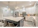 Bright white kitchen with large island, stainless steel appliances, and stylish pendant lighting at 2866 Isles Way, New Smyrna Beach, FL 32168