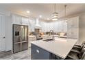 White kitchen with stainless steel appliances and large island with breakfast bar seating at 2866 Isles Way, New Smyrna Beach, FL 32168